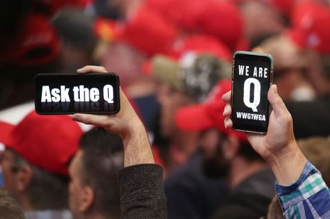 Trump-Anhänger halten ihre Telefone mit Nachrichten hoch, die sich auf die QAnon-Verschwörungstheorie beziehen