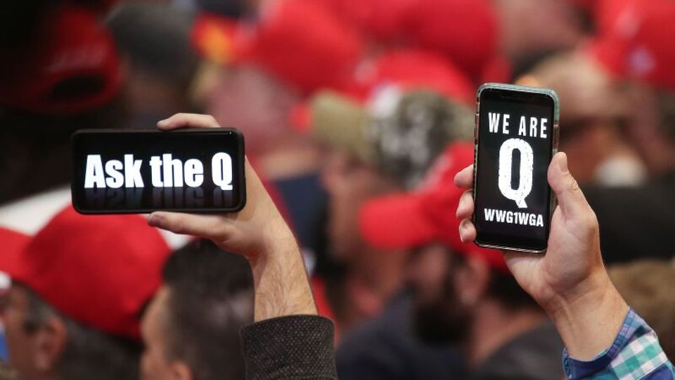 Trump-Anhänger halten ihre Telefone mit Nachrichten hoch, die sich auf die QAnon-Verschwörungstheorie beziehen