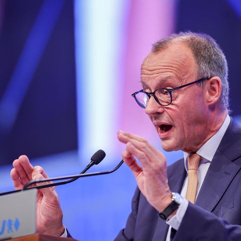 Friedrich Merz gestikuliert mit beiden Händen, während er an einem Rednerpult spricht