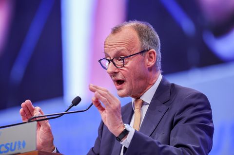 Friedrich Merz gestikuliert mit beiden Händen, während er an einem Rednerpult spricht