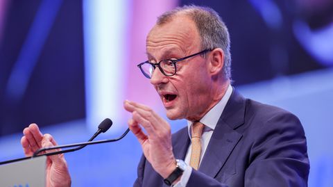 Friedrich Merz gestikuliert mit beiden Händen, während er an einem Rednerpult spricht