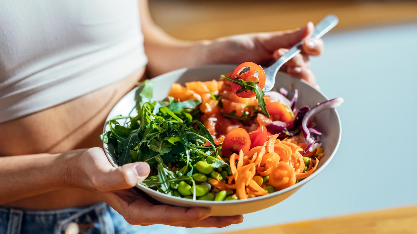 Behauptung: Vegetarische Ernährung ist gesünder und hilft beim Abnehmen Eine Frau hält eien Teller mit Gemüse und Salat in der Hand