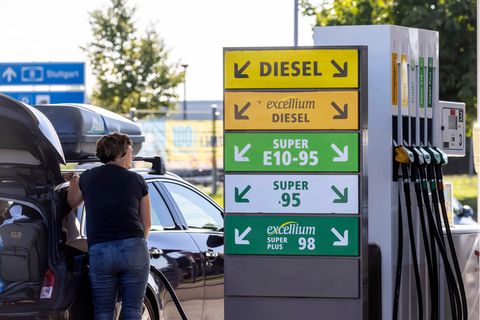 Eine Frau tankt ein Auto an einer Tankstelle