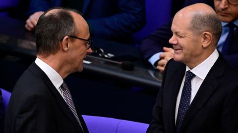 CDU-Chef Friedrich Merz (links) und Olaf Scholz im Gespräch im Bundestag.