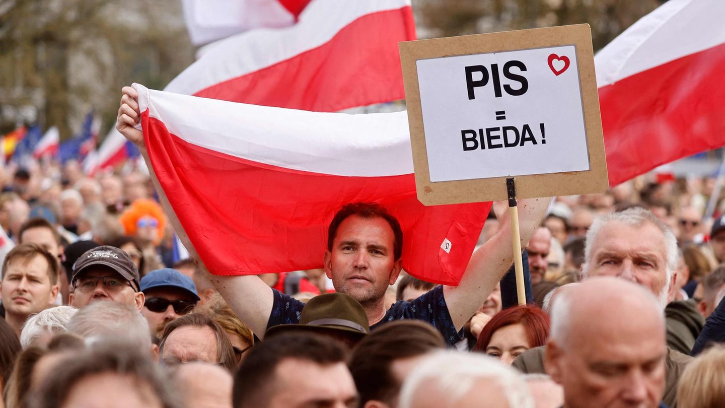 Viele polnische Flaggen, aber auch die der EU werden bei der Kundgebung geschwenkt. Auf einem Schild steht: "PIS = BIEDA!" – auf deutsch "PIS = Armut".