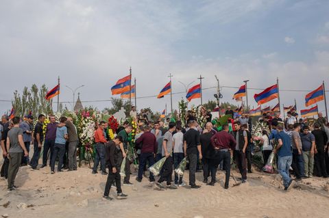 Armenische Flaggen werden während einer Beisetzung gefallener Soldaten in Bergkarabach hochgehalten