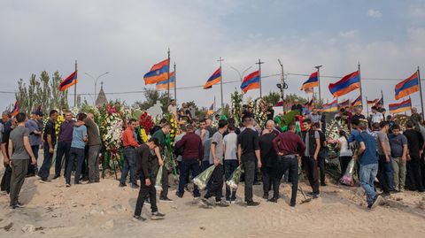 Armenische Flaggen werden während einer Beisetzung gefallener Soldaten in Bergkarabach hochgehalten
