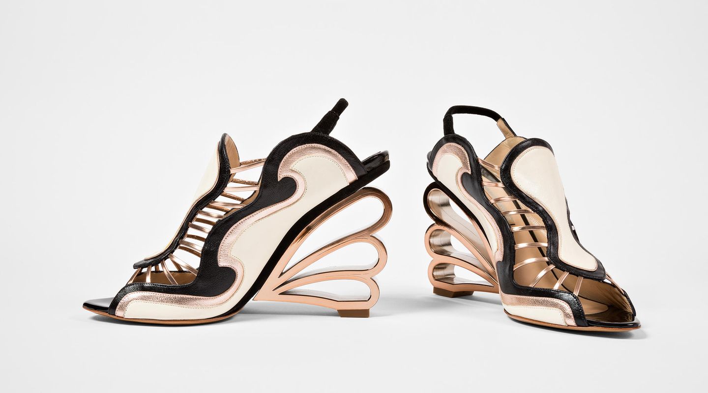 Die verwegenen Kreationen von Nicholas Kirkwood sind ungenierte Statements. Ihre skulpturale Ästhetik vereint unerwartete Materialien mit Silhouetten, die theatralisch und zugleich sexy sind. Beim Design gilt sein besonderes Augenmerk vor allem dem Absatz, sei er gekerbt, speziell geformt oder aus ungewöhnlichen Materialien gefertigt. Das Modell auf dem Bild stammt aus der Frühjahrskollektion 2011 und zeigt einen dieser kreativen Absatz-Schöpfungen Kirkwoods.  Neben den ausgefallenen Designs trugen auch viel beachtete Laufstegkooperationen mit Labels wie Rodarte, Fendi und Erdem dazu bei, Kirkwoods internationale Bekanntheit zu steigern.