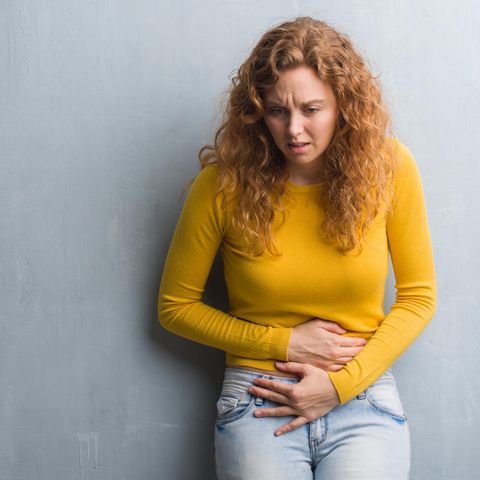 Frau hält sich den Bauch vor Schmerzen