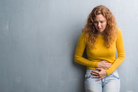 Frau hält sich den Bauch vor Schmerzen