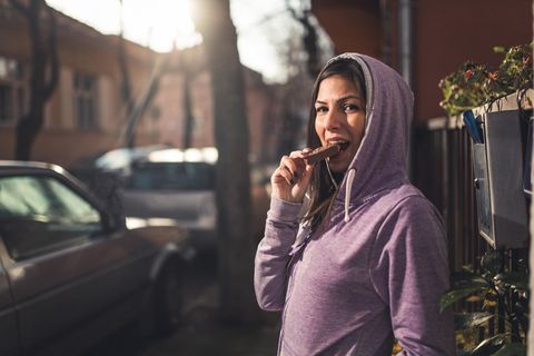 Sportlerin isst einen Schokoriegel