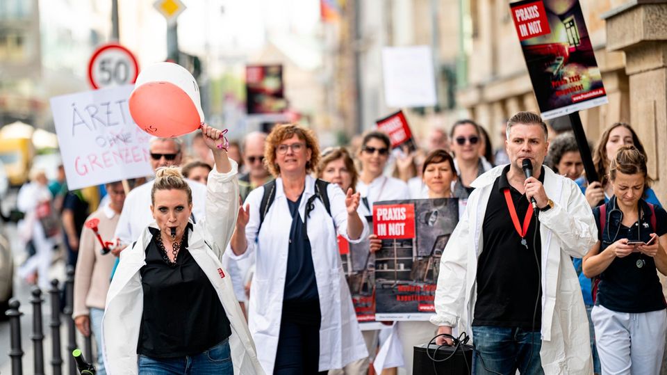 Ärzte gehen bei dem Protestmarsch "Ärzte in Not" durch Berlin Mitte