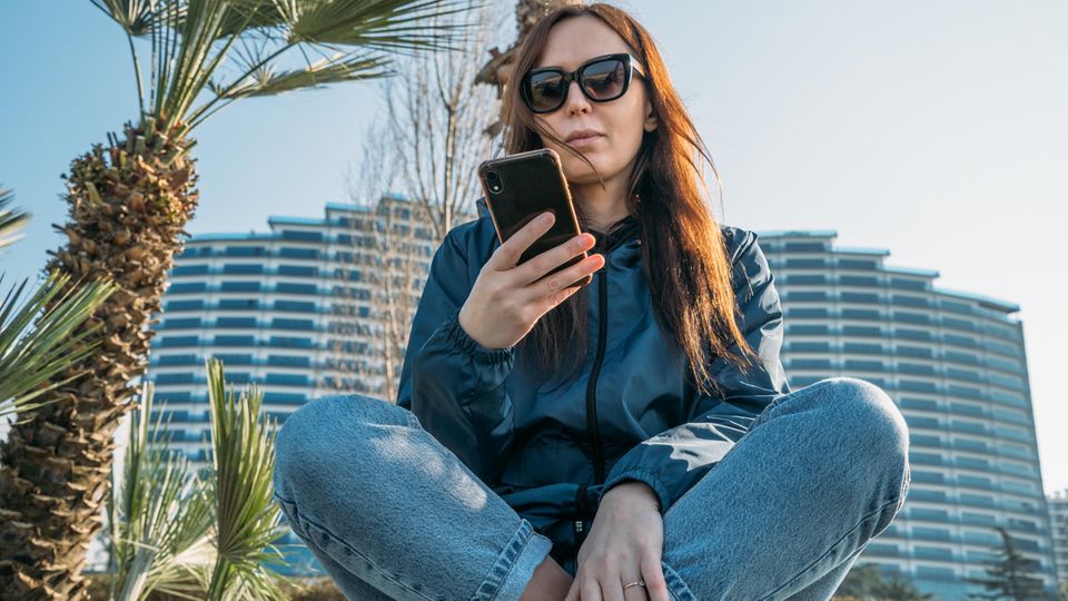 Junge Frau blickt auf ihr Handy