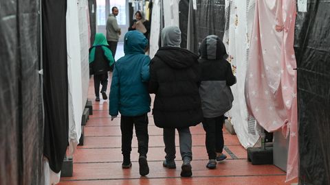 Drei Kinder gehen Hand in Hand durch eine Flüchtlingsunterkunft in Bensheim, Hessen