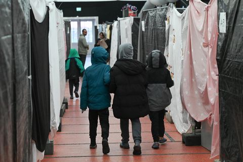 Drei Kinder gehen Hand in Hand durch eine Flüchtlingsunterkunft in Bensheim, Hessen
