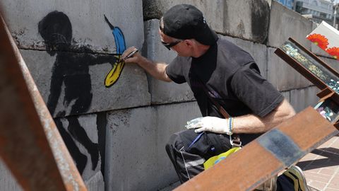 Thomas Baumgärtel sprüht eine Banane neben ein Werk von Banksy