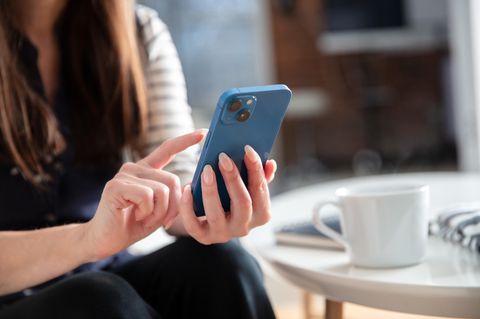 Welches iPhone kaufen: Eine Frau tippt auf ihrem iPhone 14