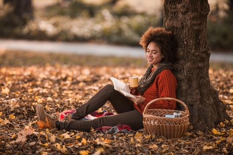 Frau liest im Herbst ein Buch