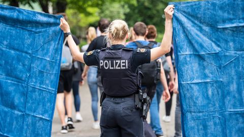 Polizistin in Bremerhaven schirmt Schüler:innen mit Plane ab