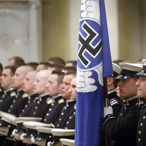 Angehörige der finnischen Luftwaffe mit blauer Hakenkreuzflagge