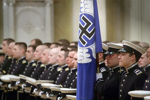 Angehörige der finnischen Luftwaffe mit blauer Hakenkreuzflagge