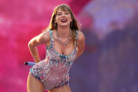 Taylor Swift steht lachend auf einer Bühne