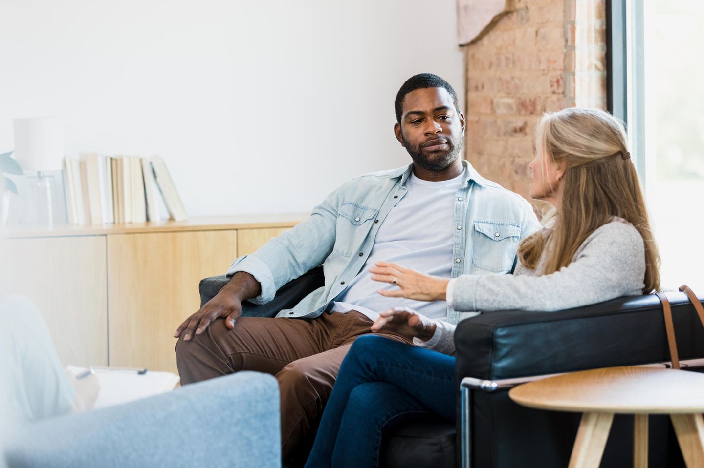 Ein Mann und eine Frau sitzen nebeneinander auf einer Couch