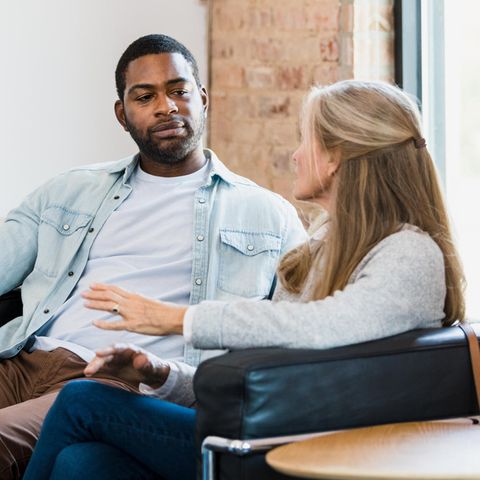 Ein Mann und eine Frau sitzen nebeneinander auf einer Couch