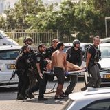 Mitglieder der israelischen Sicherheitskräfte tragen nach einem Raketenangriff aus dem Gazastreifen in Aschkelon einen Verletzten auf einer Trage