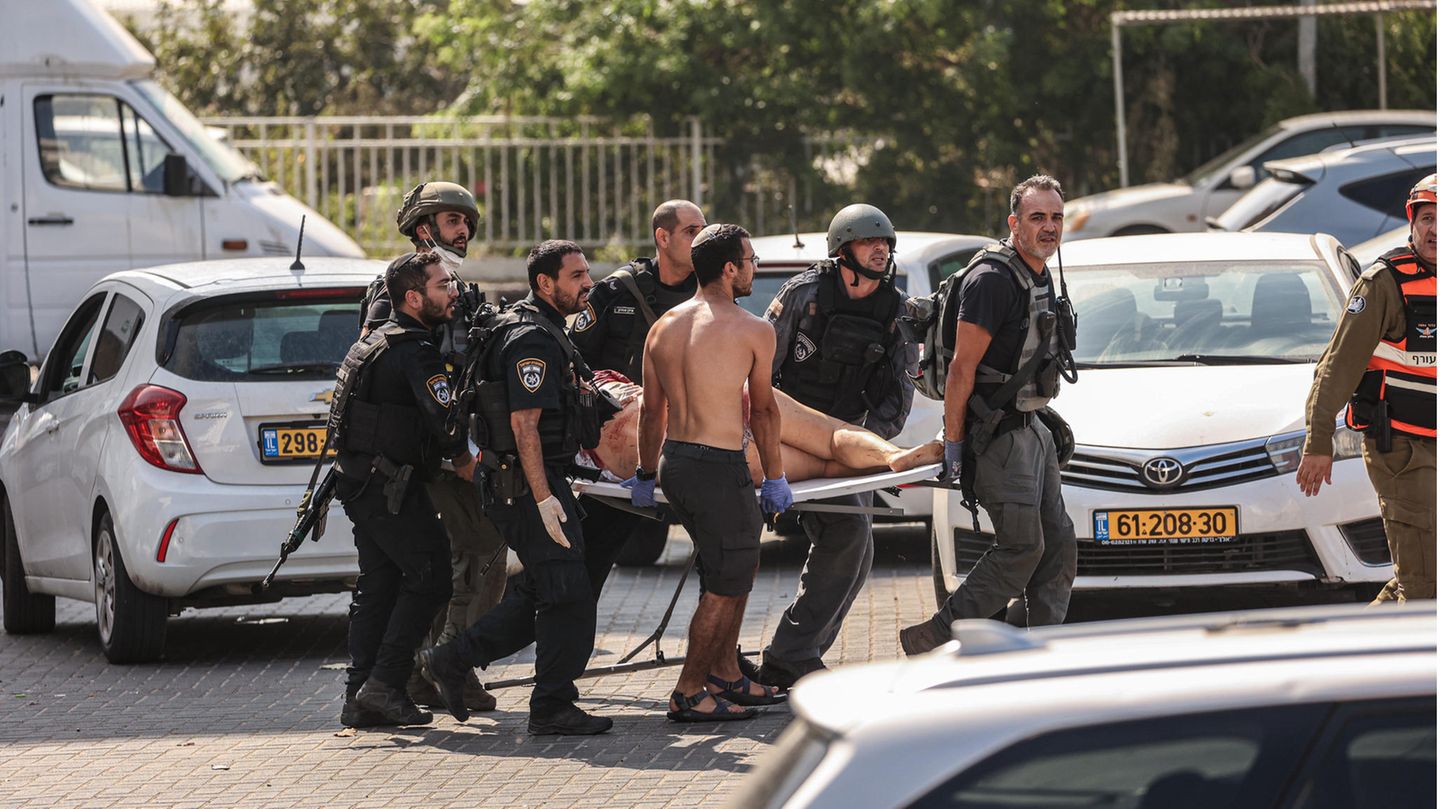 Mitglieder der israelischen Sicherheitskräfte tragen nach einem Raketenangriff aus dem Gazastreifen in Aschkelon einen Verletzten auf einer Trage
