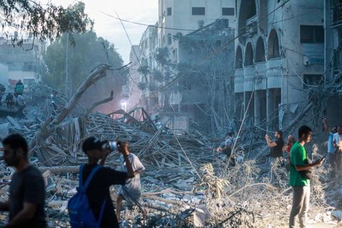 Gewalt und Angst erleben auch die Menschen in Gaza. Hier dokumentieren einige die Trümmer eines Turms, der bei einem israelischen Luftangriff in Gaza-Stadt zerstört wurde.