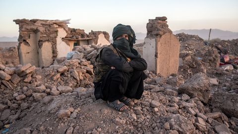 Ein Mann sitzt vor den Trümmern seines Hauses