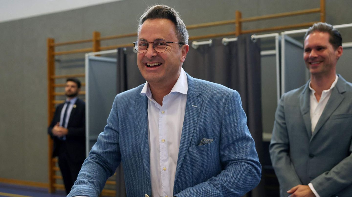 Luxemburgs Premierminister Xavier Bettel (Mitte) und sein Ehemann Gauthier Destenay bei der Stimmabgabe