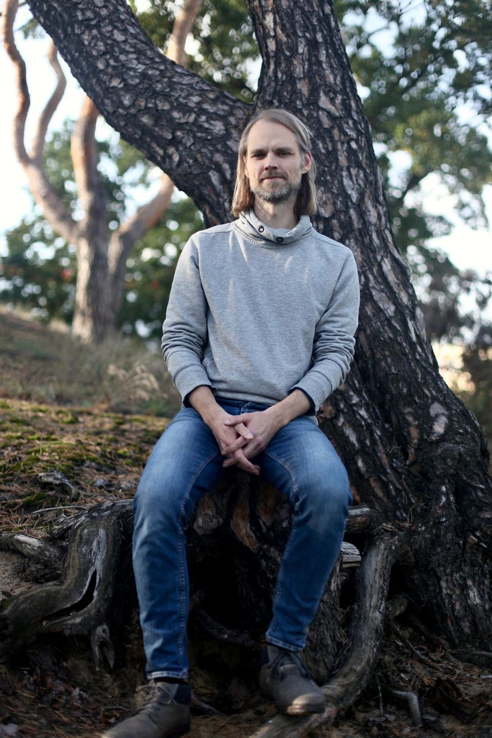 Christopher Hartl lehnt an einer Kiefer