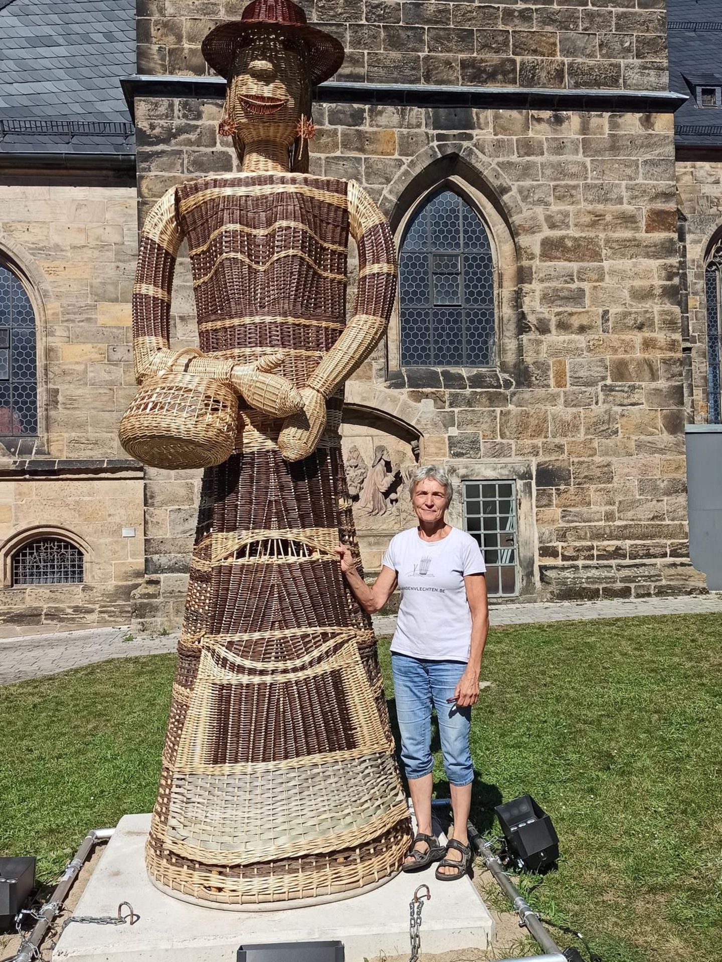 Frau neben einem geflochtenen Riesen