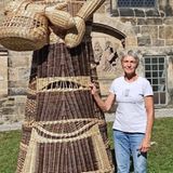 Frau neben einem geflochtenen Riesen