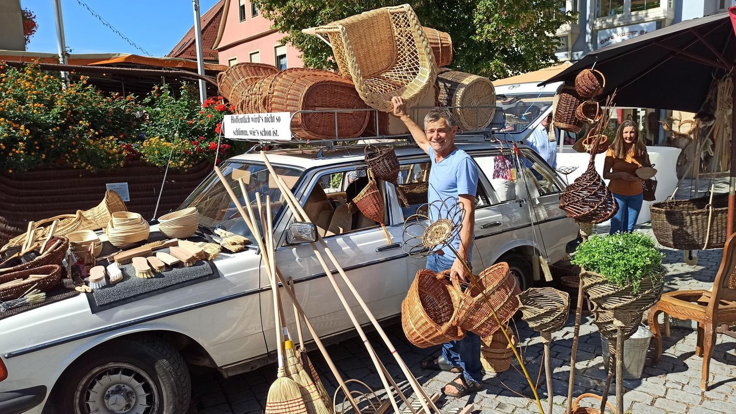 Mann neben Auto-Kombi und vielen Körben
