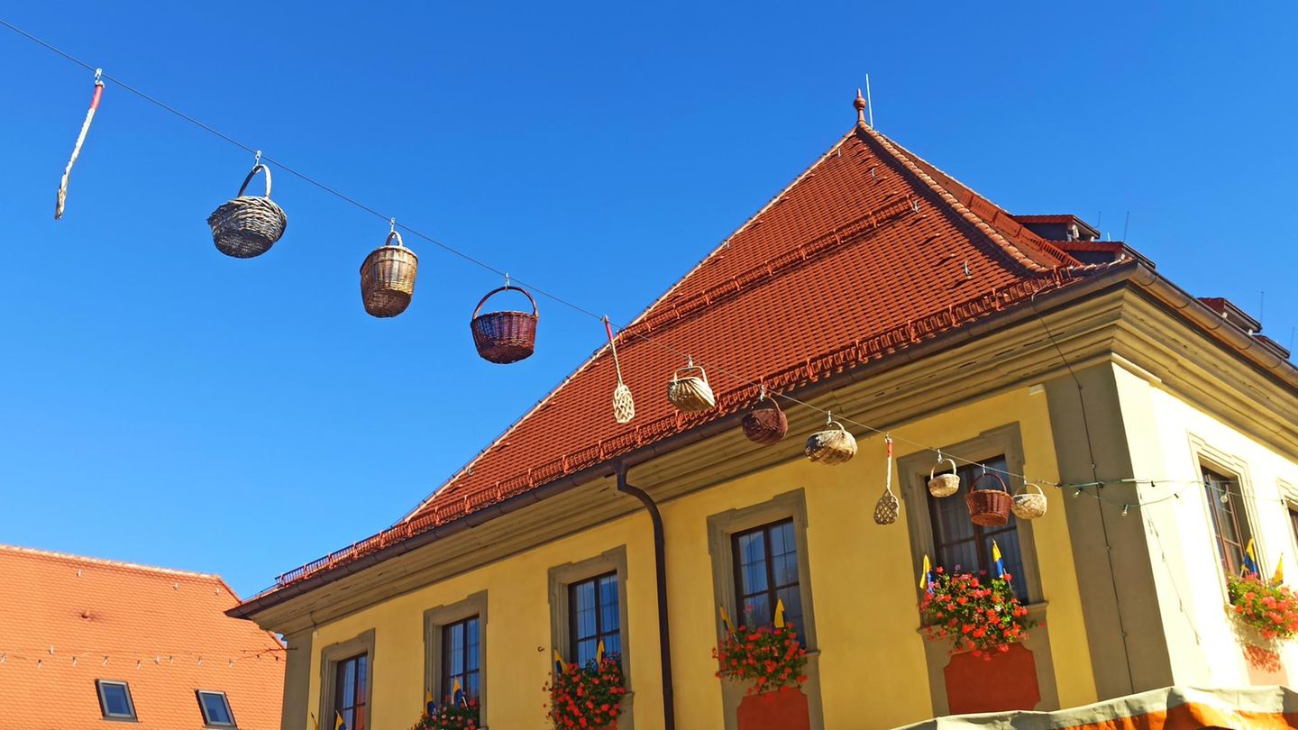 Band mit Körben zwischen zwei Häusern Band mit Körben zwischen zwei Häusern