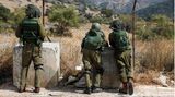 Drei israelische Soldaten blicken über den Zaun in Richtung Gazastreifen