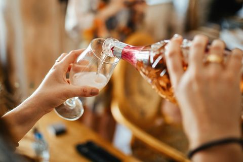 Schweiz: Frau schenkt Champagner in Glas ein