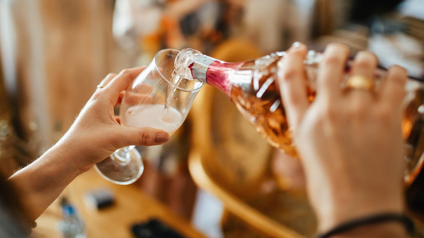 Schweiz: Frau schenkt Champagner in Glas ein