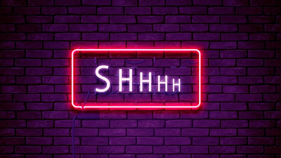 Ein neon beleuchtetes Schild in dem "shhhh" steht