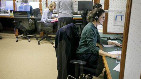 Eine Frau mit Headset sitzt an einem Tisch: Mitarbeiter des Krisenstabes telefonieren im Jahr 2020.