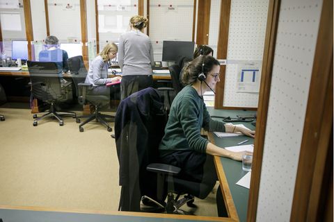Eine Frau mit Headset sitzt an einem Tisch: Mitarbeiter des Krisenstabes telefonieren im Jahr 2020.