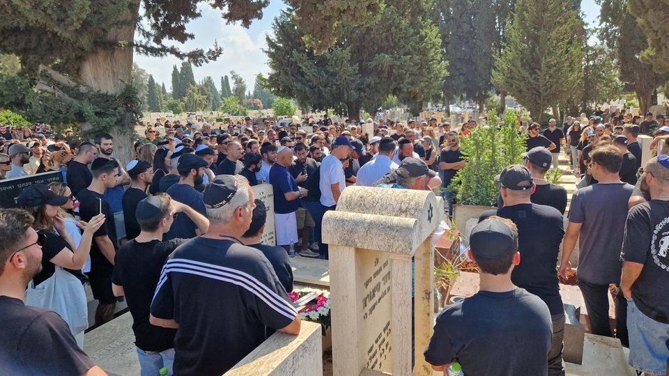 Hunderte Menschen stehen um das Grab des 26-jährigen Liam.