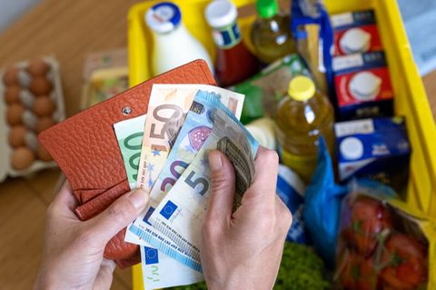 Geldscheine und eine Kiste mit Einkäufen