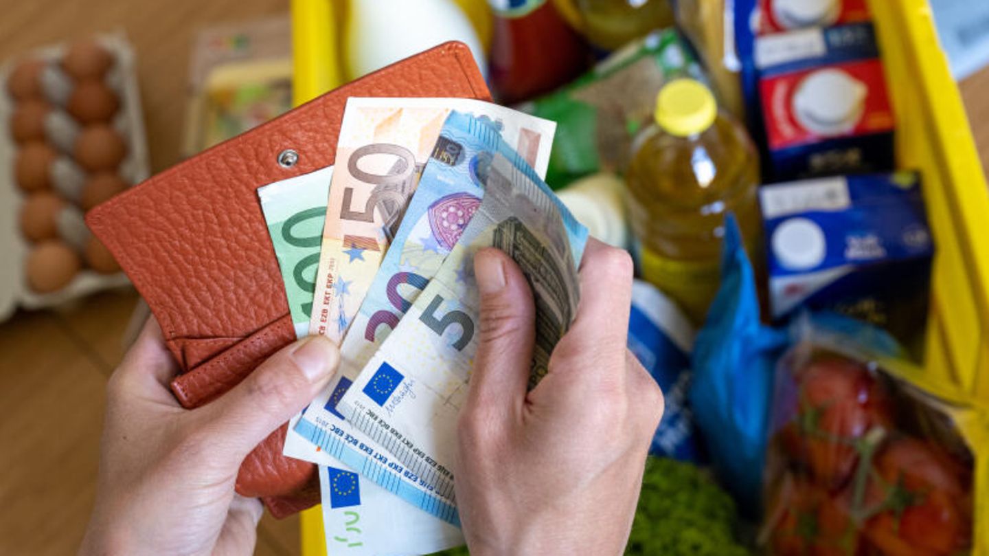 Geldscheine und eine Kiste mit Einkäufen