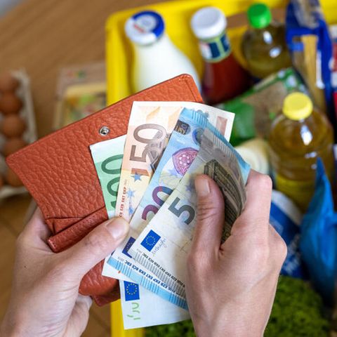 Geldscheine und eine Kiste mit Einkäufen