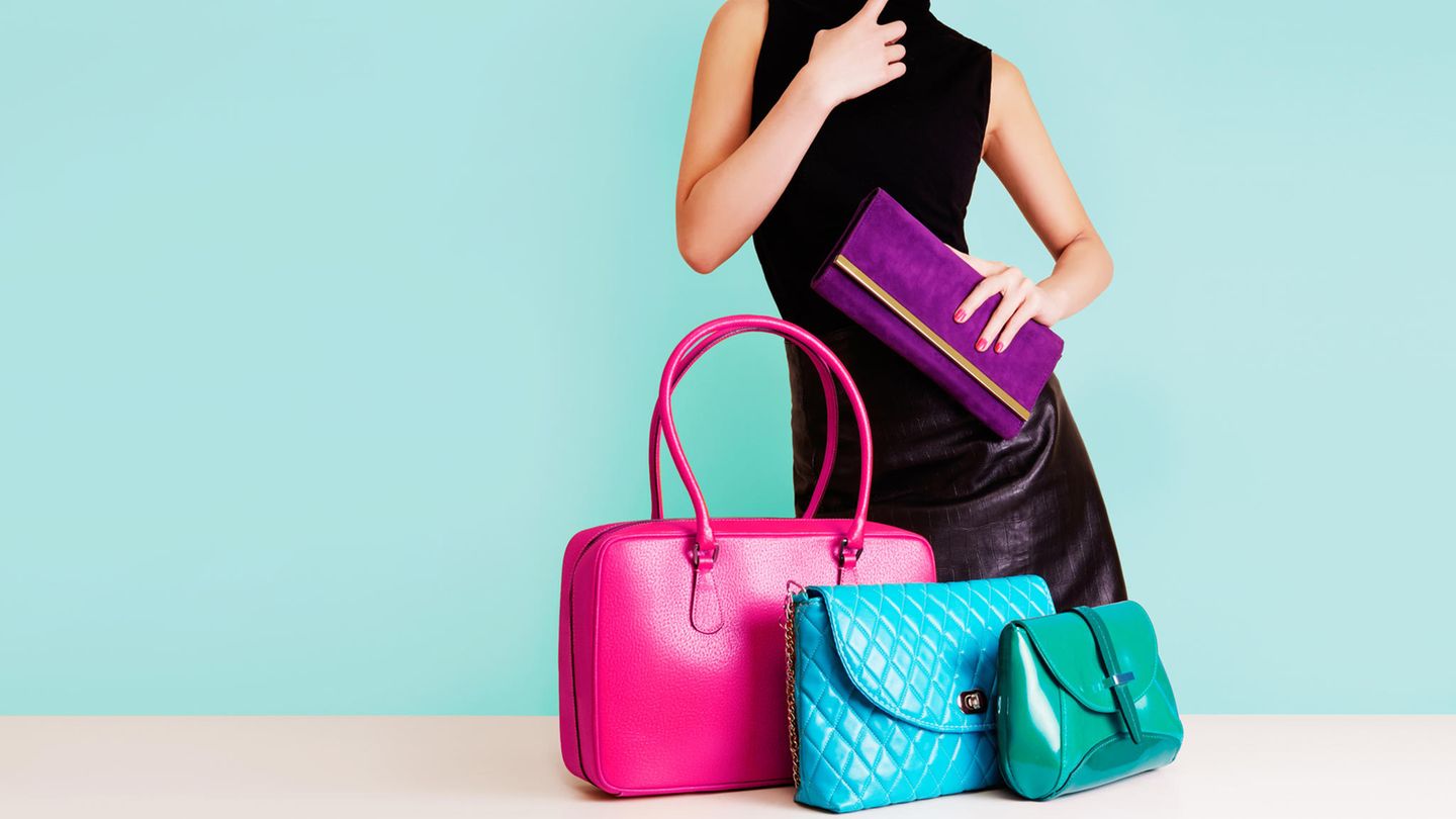 Puffer Bag: Eine Frau steht grübelnd vor einer Auswahl von Handtaschen.