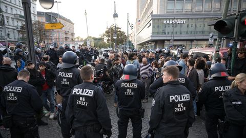 Polizeibeamte stehen im Berliner Stadtteil Neukölln auf dem Hermannplatz vor einer Gruppe, aus der "Free Palestine"-Rufe kamen